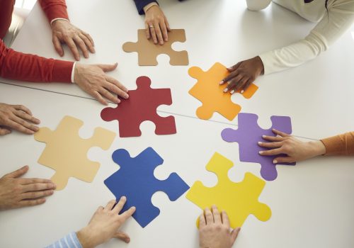 Team of business people joining colorful puzzle